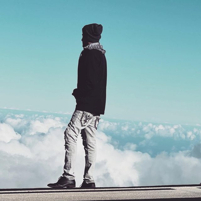 Leo standing at an overlook above a sea of clouds.