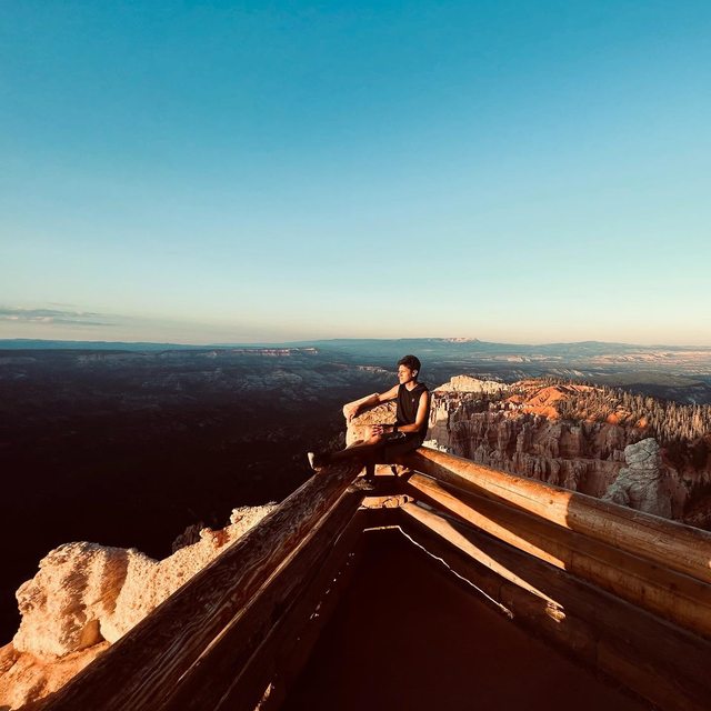 Leo at a canyon overlook in warm evening light, surrounded by rock formations.