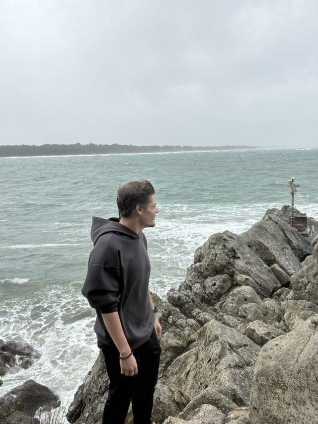 Chris standing on a rocky coastline and looking out over the sea.